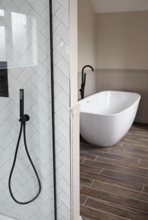 uma banheira branca na casa de banho com um chuveiro em Bulls Head Inn Rooms em Alton