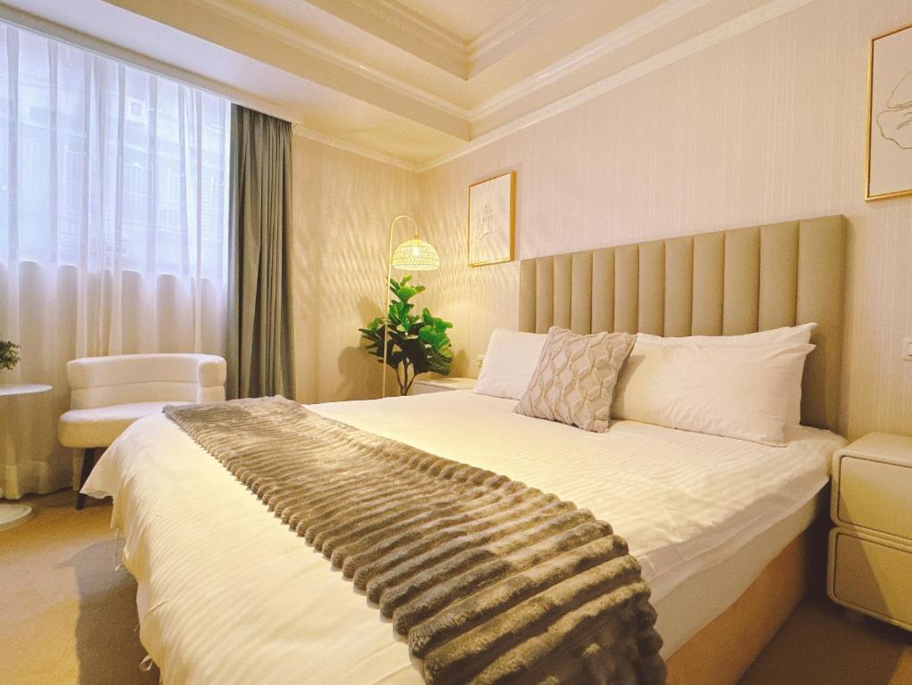 a bedroom with a large bed with a large window at Shanger Hotel in Taipei