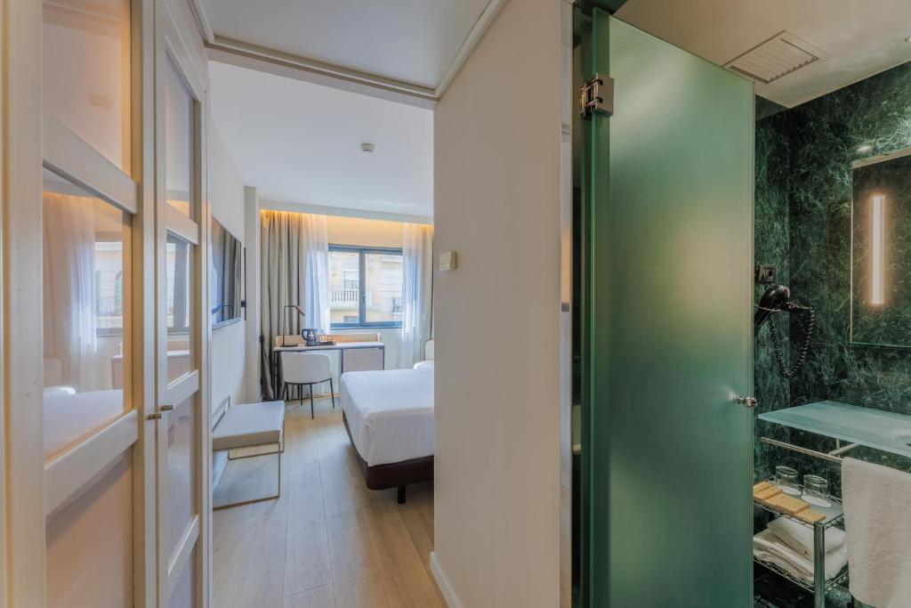 - une chambre avec un lit et une salle de bains dans l'établissement Hotel Vilamarí, à Barcelone