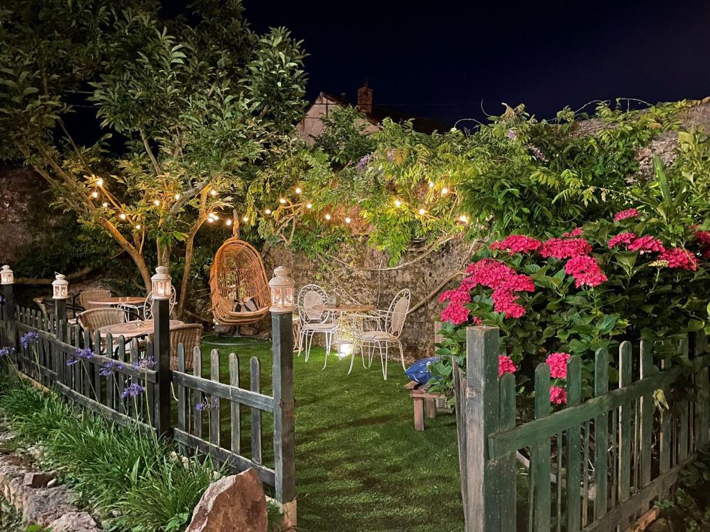 einen Zaun mit Tischen und Stühlen in einem Garten in der Nacht in der Unterkunft Mar Del Sueve in Colunga