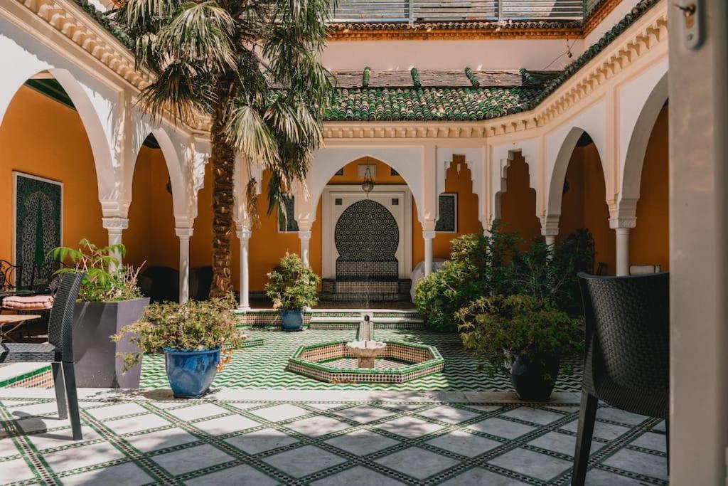 une cour avec une fontaine au milieu d'un bâtiment dans l'établissement Riad privé en plein centre de Vichy, à Vichy