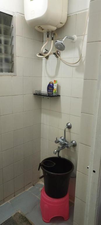 baño con cubo y grifo en RUKMINI Apartment, en Bangalore