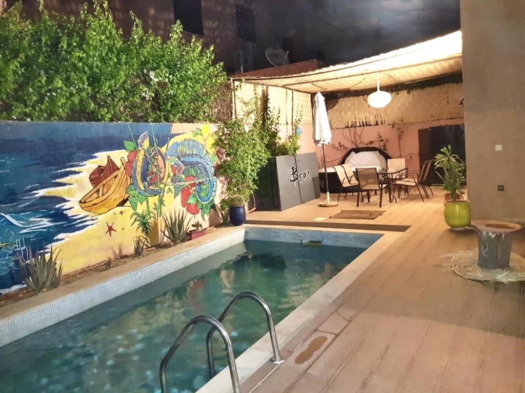 ein Pool mit einem Gemälde an der Wand in der Unterkunft 3 bedrooms villa with private pool enclosed garden and wifi at Marrakech in Aït Ali