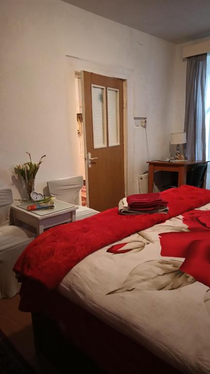 - une chambre avec un grand lit et des draps rouges dans l'établissement Liberty Apartment, à Cluj-Napoca