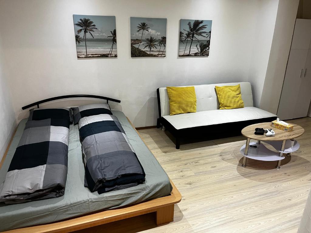 een slaapkamer met een bed, een bank en een tafel bij Apartmán u nádraží in Bílina
