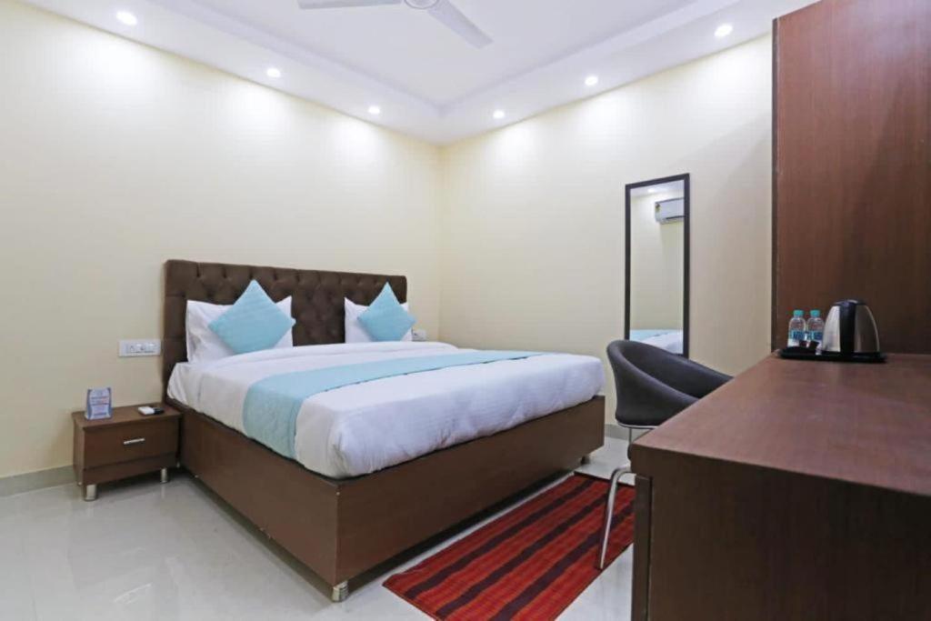Hotel Mannat at Paschim Vihar في نيودلهي: غرفة في الفندق بها سرير ومكتب ومكتب