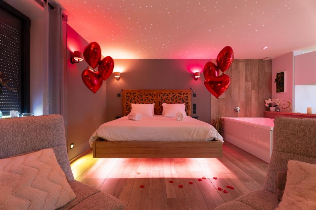 a bedroom with a bed and two hearts on the ceiling at La Suite SPA privatif du Moulin in Saint-Laurent-dʼAndenay