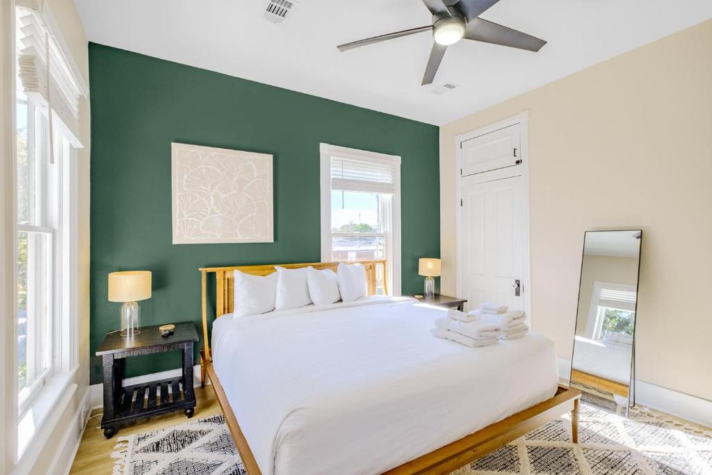 um quarto com uma cama branca e paredes verdes em Aerie Loft em Biloxi