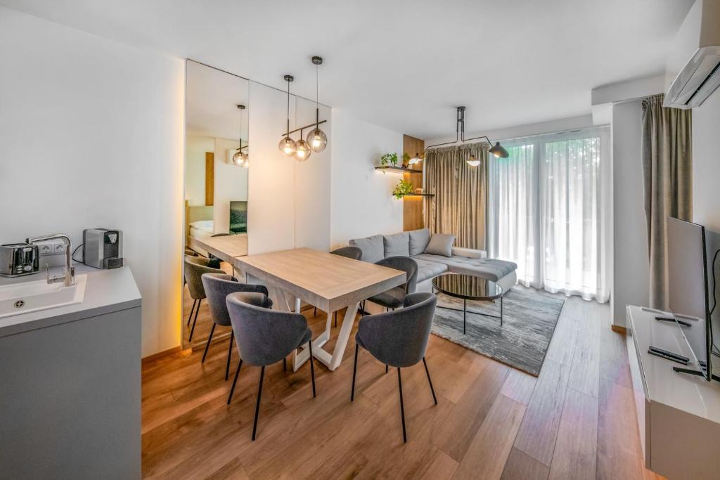 Il comprend une cuisine et un salon avec une table et des chaises. dans l'établissement Napfény Resort by HelloBalatonlelle, à Balatonlelle