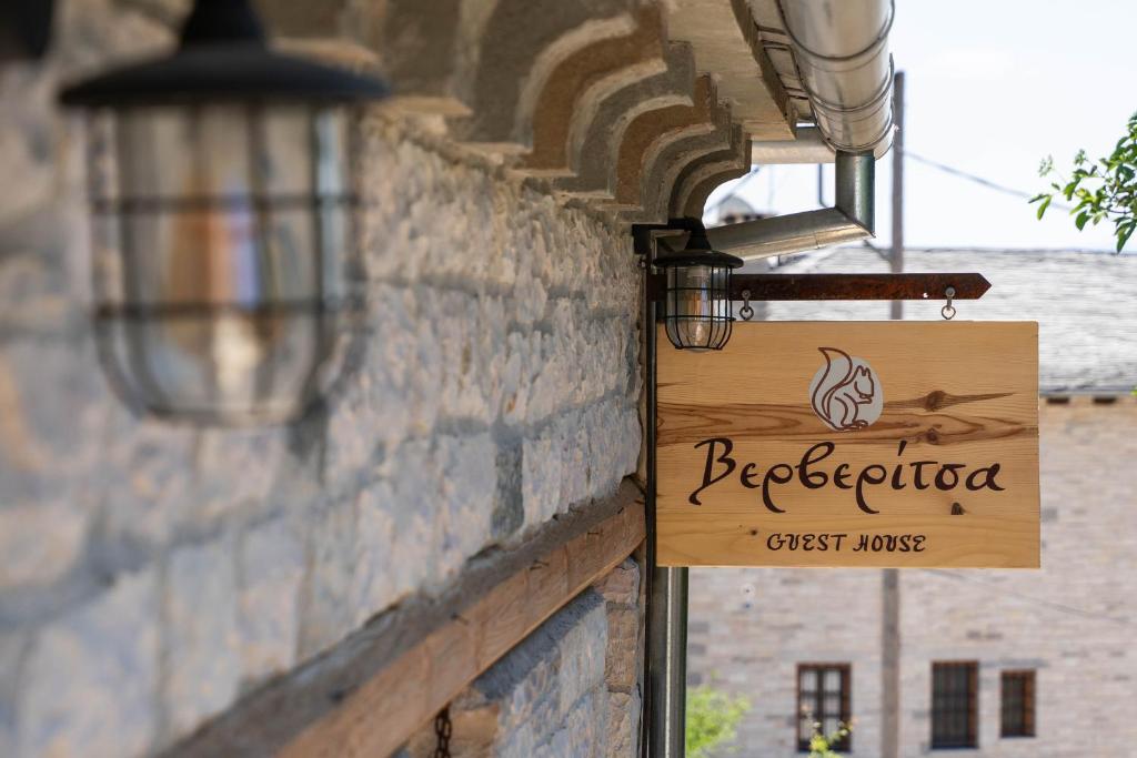 a sign for a guest house hanging on a brick wall at Βερβερίτσα in Monodendri