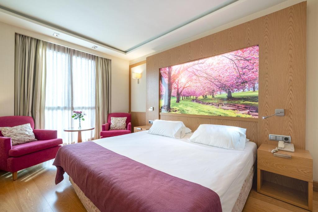 ムルシアにあるホテル ネルバのベッド付きの客室で、壁には絵画が飾られています。