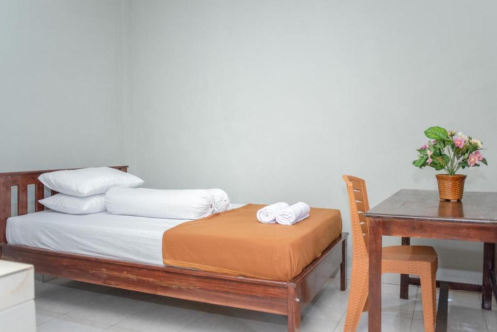 Amor Homestay near Eltari International Airport Mitra RedDoorz في كوبانغ: غرفة نوم بسرير ومكتب وطاولة