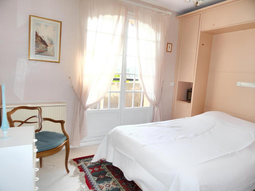 ein weißes Schlafzimmer mit einem Bett und einem Fenster in der Unterkunft Maison de 2 chambres avec vue sur la mer piscine partagee et jardin clos a Mouans Sartoux in Mouans-Sartoux