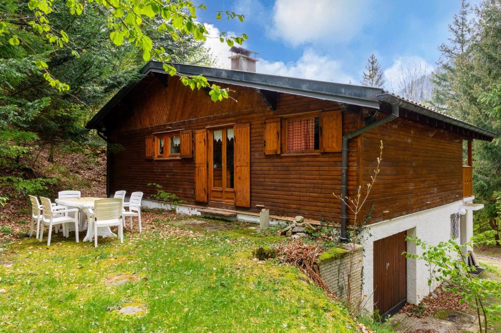 a small wooden house with a table and chairs at Chalet Les Airelles in Mittlach