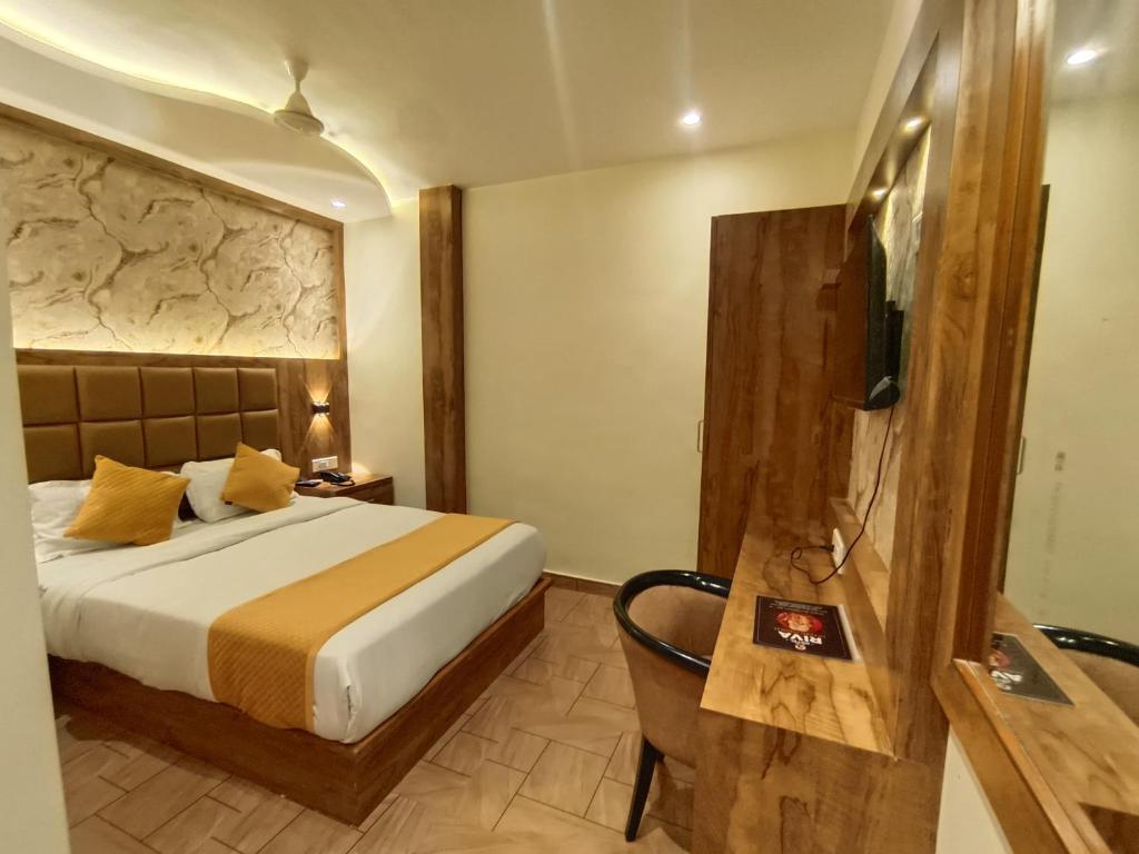 a hotel room with a bed and a television at Hotel Riva International Goregaon- Near NESCO in Mumbai