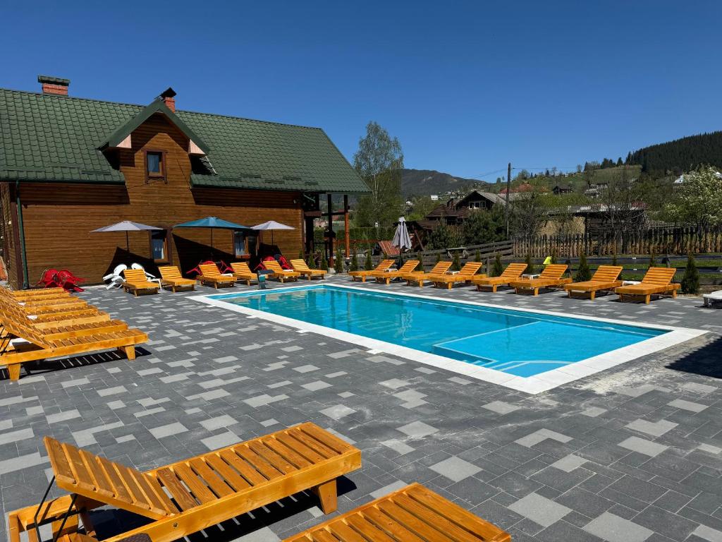 a swimming pool with lounge chairs and a resort at Готель Bliznuky in Vorokhta
