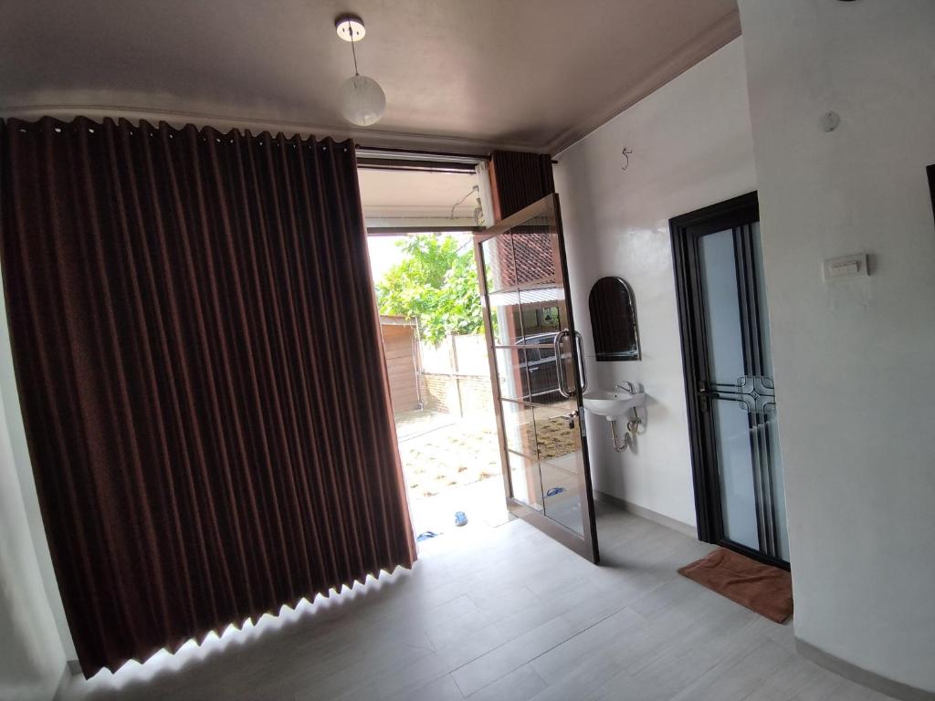 una camera con porta aperta ad una stanza con televisore di Krui NFs hotel a Krui
