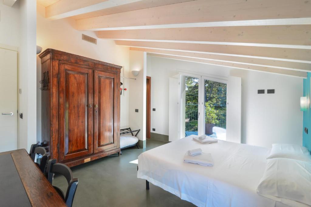 a bedroom with a white bed and a wooden cabinet at Marilena in Castelnuovo del Garda