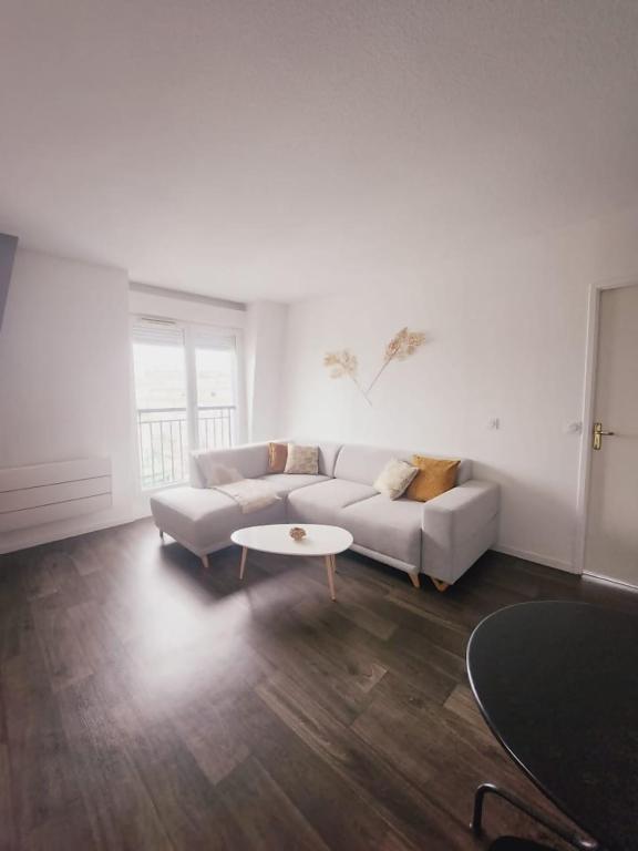een woonkamer met een bank en een tafel bij Apartamento en Disneyland Paris in Chessy