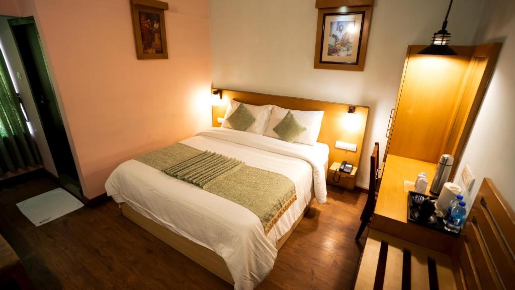 Postel nebo postele na pokoji v ubytování HillView Munnar