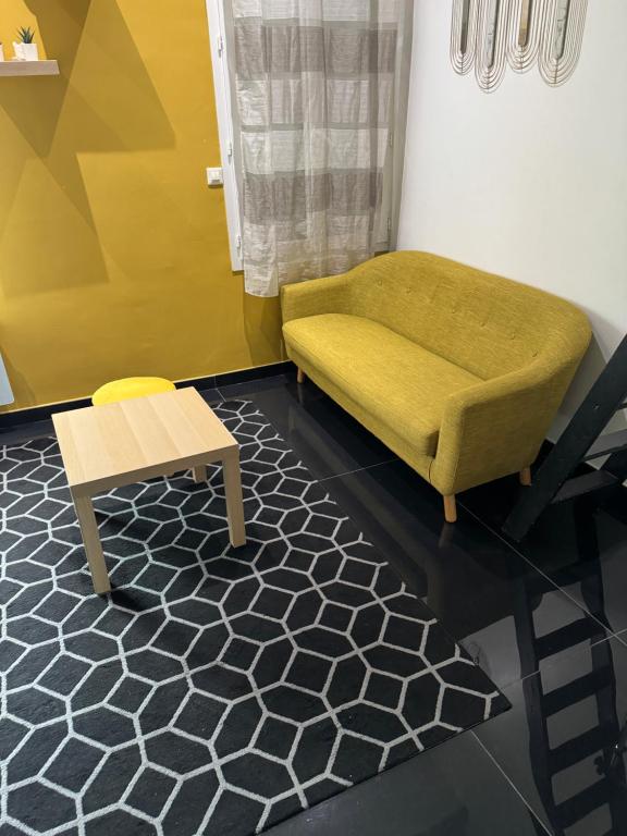 un salon avec une chaise verte et une table dans l'établissement Charmant studio proche mer, à Nice