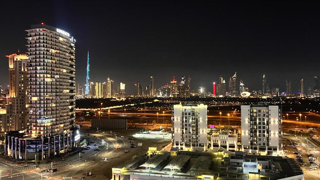 a view of a city at night with buildings at Cozy Central Apt with Parking and Skyline View in Dubai