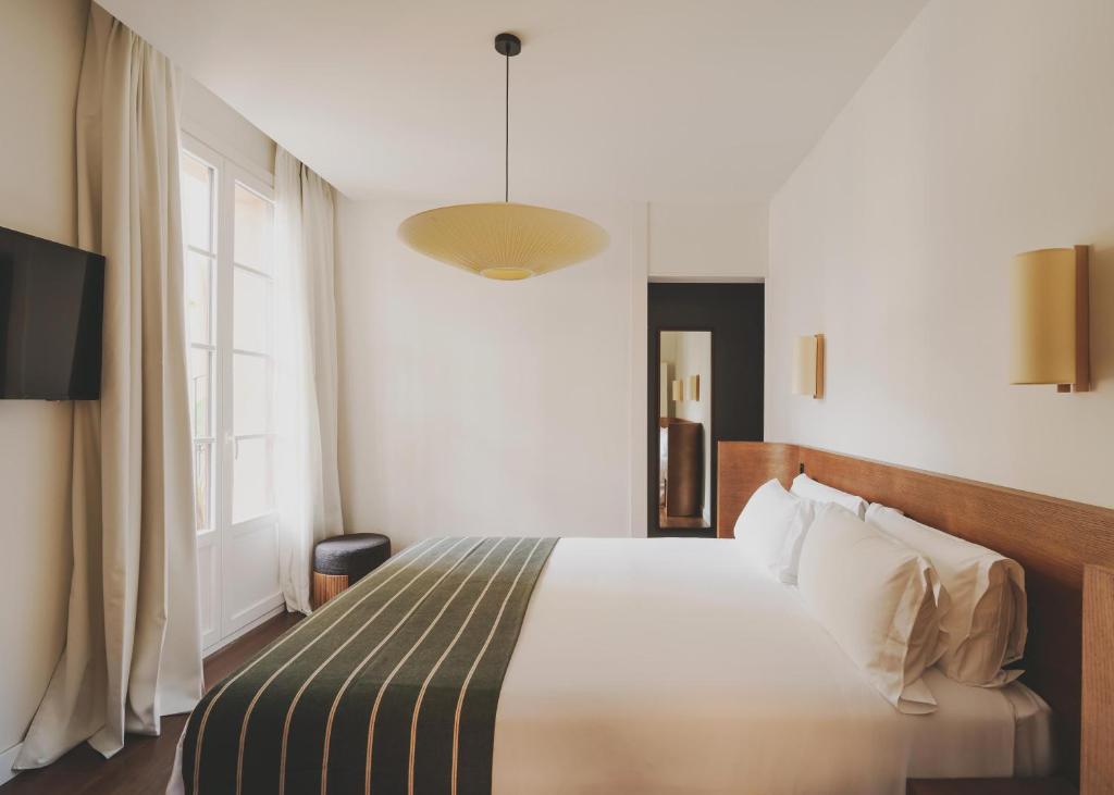 a bedroom with a bed and a large window at Hotel Regina Barcelona in Barcelona