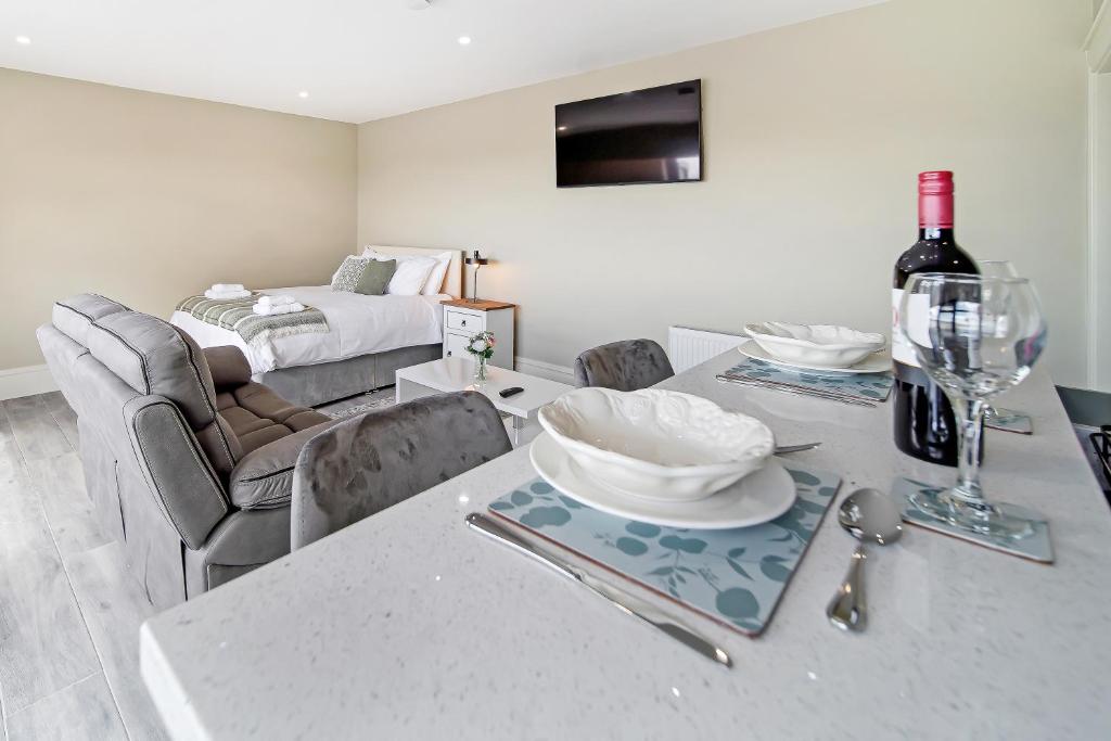 ein Esszimmer mit einem Tisch und einer Flasche Wein in der Unterkunft Seaview Lodge Studio 'Sleeping 2 guests' in Burnfoot