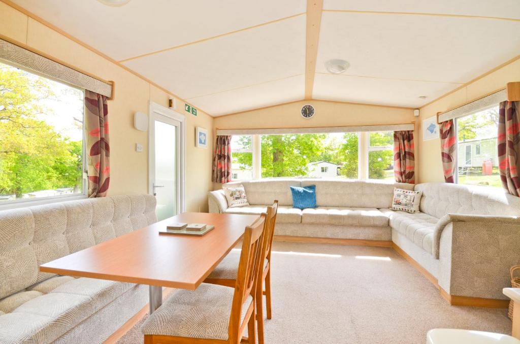 a caravan living room with a table and a couch at Greenwood in Cowes