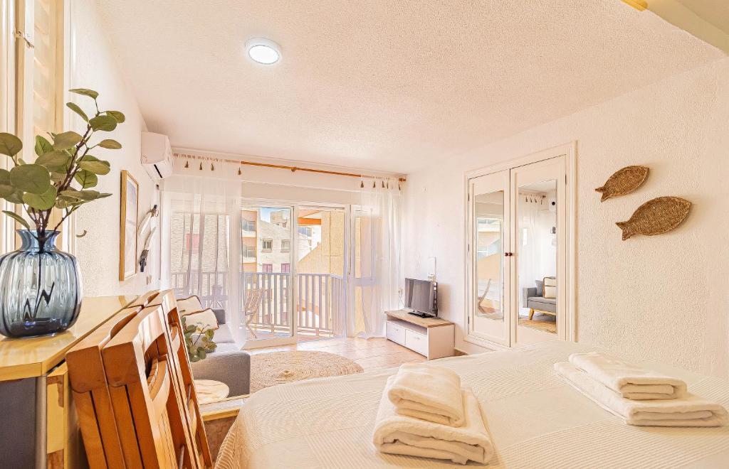 Una sala de estar con dos camas y un televisor. en LA PECERA - La Manga del Mar Menor - Edificio Mónaco - Kilómetro 7 - cama plegable y sofá-cama, en La Manga del Mar Menor