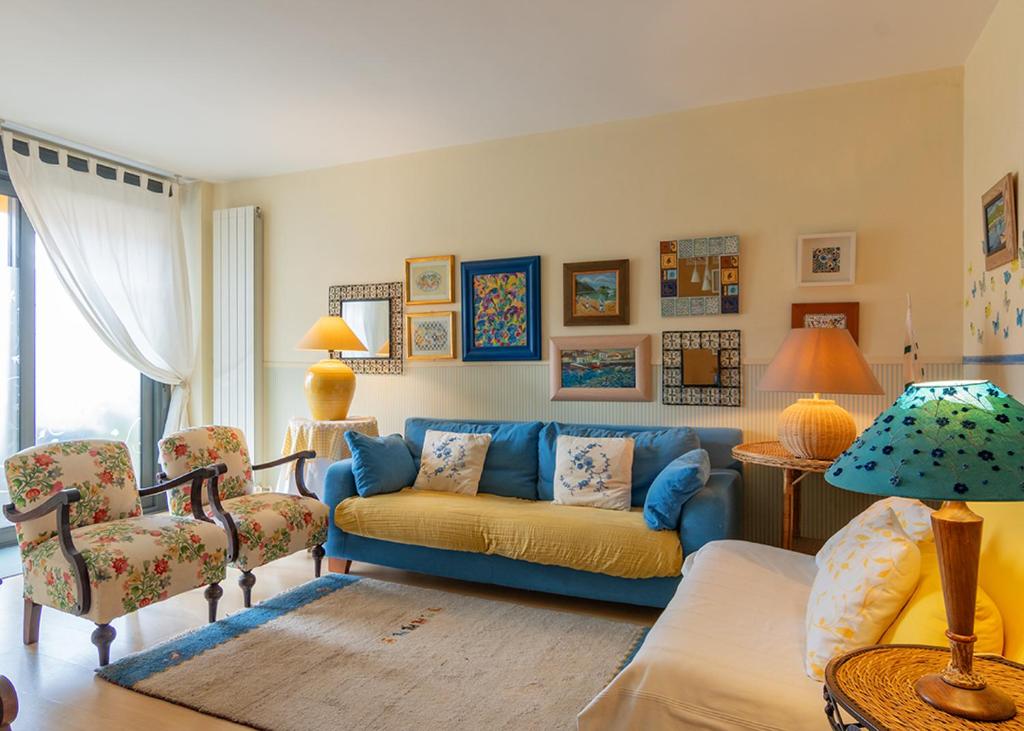 - un salon avec un canapé bleu et des chaises dans l'établissement Apartamento Sueve 20, à Colunga