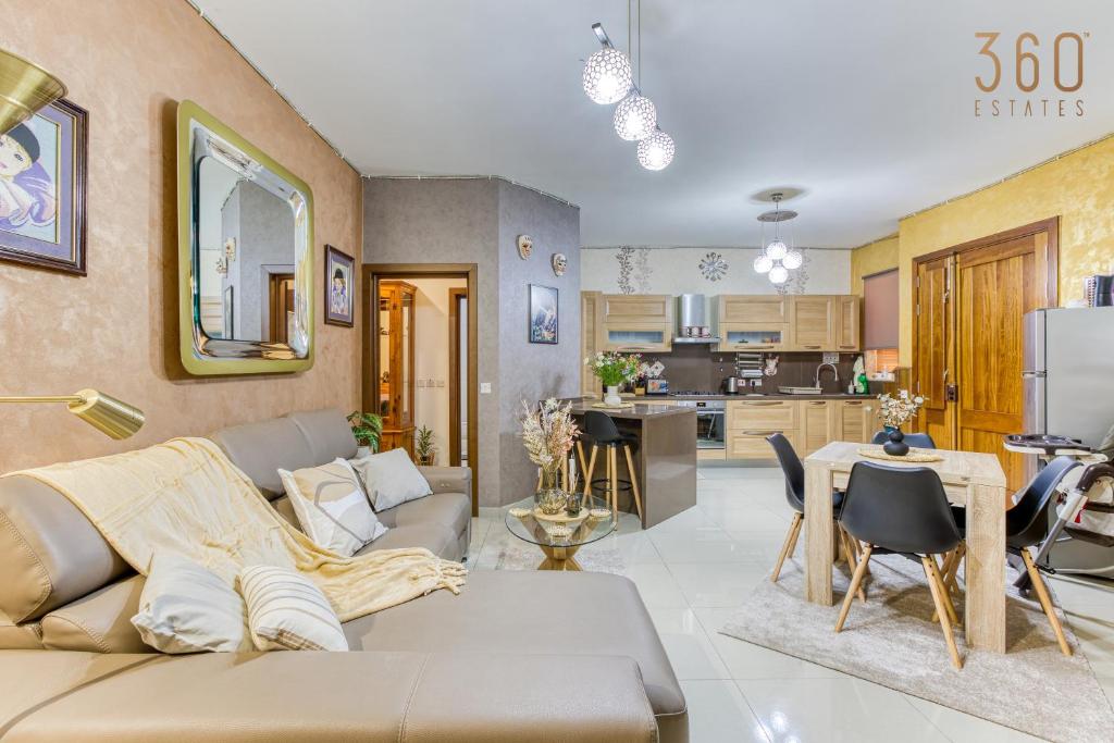 Il comprend un salon avec un canapé et une cuisine. dans l'établissement Charming 2BR home in the heart of Marsaxlokk by 360 Estates, à Marsaxlokk