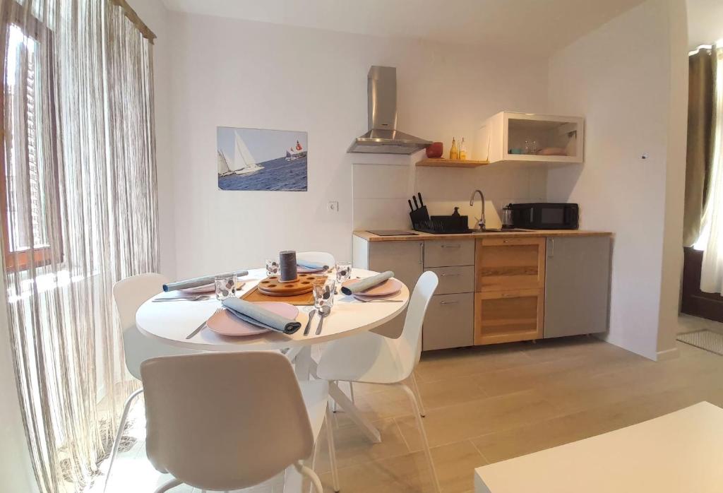 a kitchen with a white table and chairs in a room at Eli i Val in Rovinj
