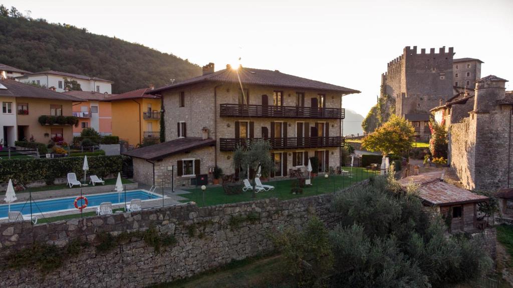 um edifício com piscina e um castelo ao fundo em Villa Stanga - Gardaslowemotion em Tenno