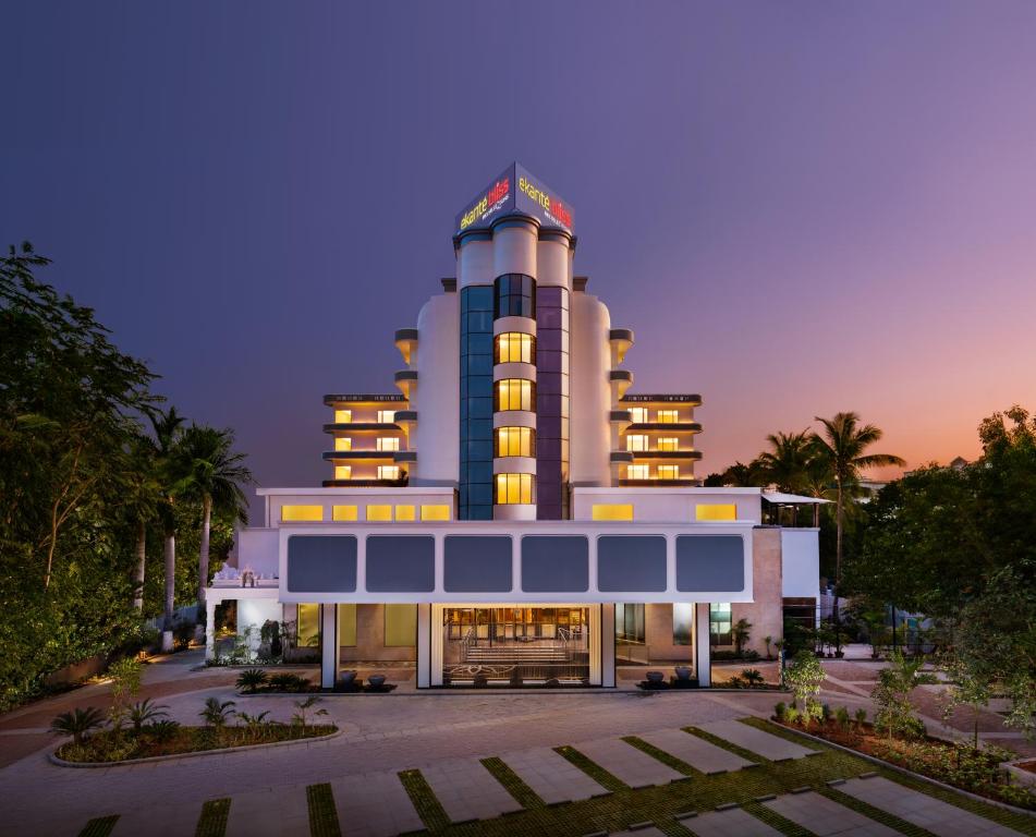 a large building with a clock tower at dusk at Ekante Bliss Tirupati - IHCL SeleQtions in Tirupati