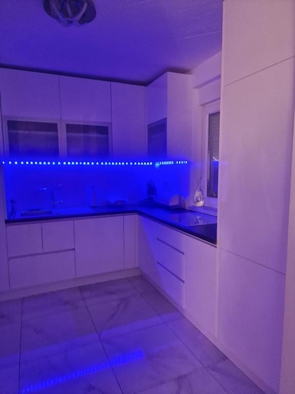 uma cozinha com armários brancos e iluminação azul em Villa Ema em Zagreb