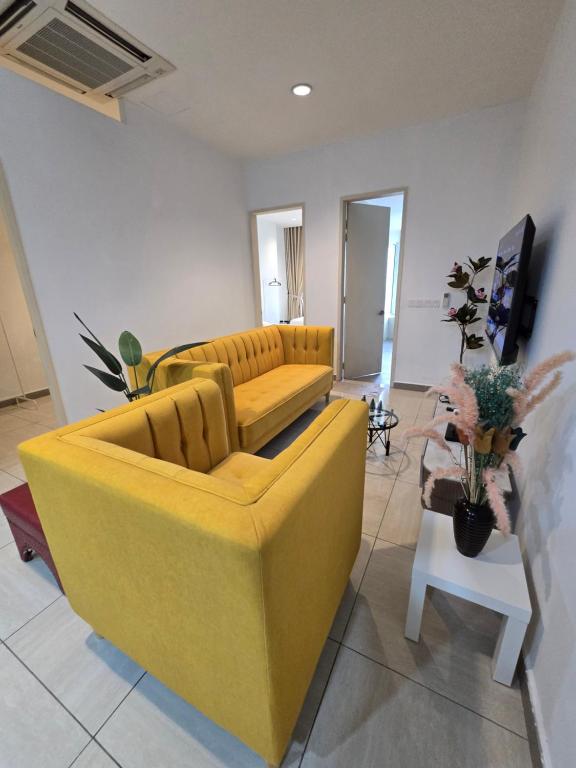a living room with a yellow couch and a table at The Octagon Ipoh City Centre Leisure Suite in Ipoh