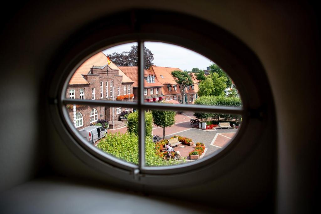 a view from a round window of a city at Hotel Busch in Westerstede