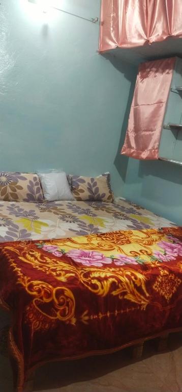 a bed with a colorful blanket on it in a room at Shri Ganga kashi homestay in Varanasi
