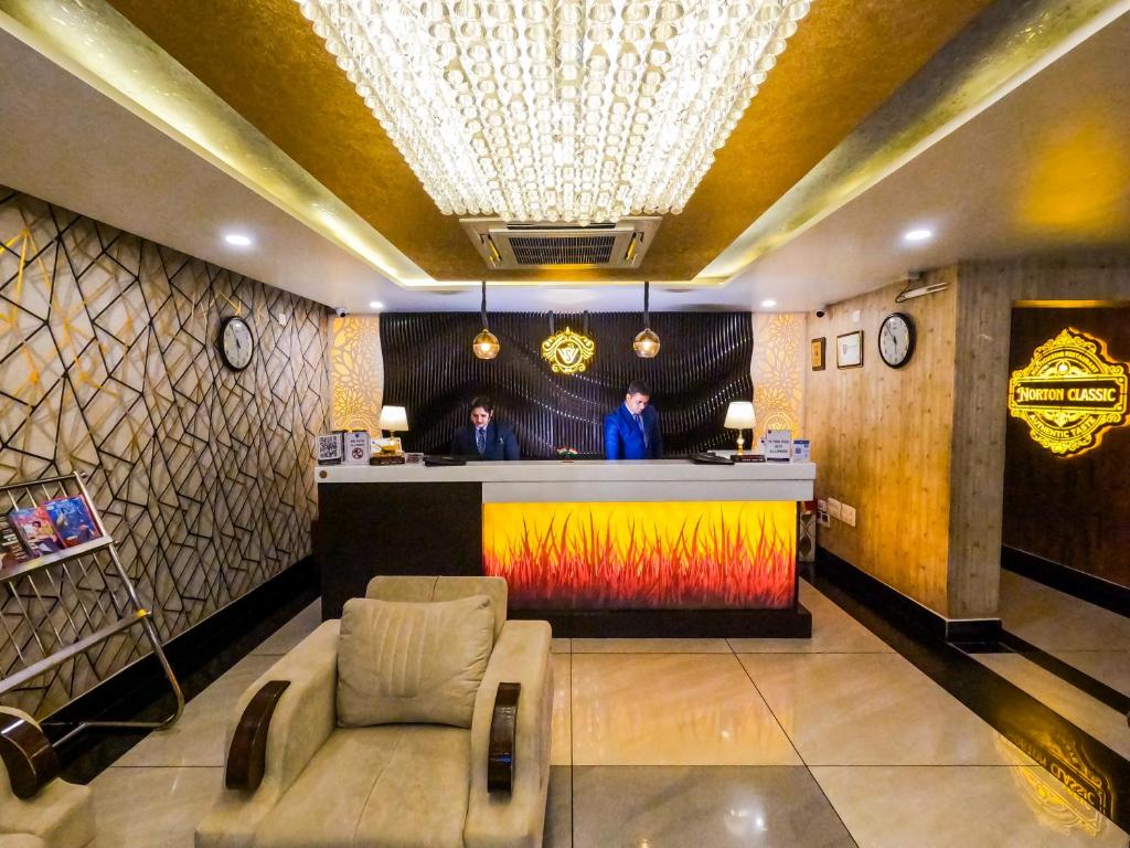 Hotel Sidh Vedantha في باتنا: رجلان يقفان في حانة في بهو الفندق