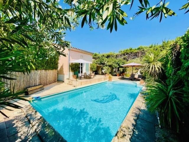 une grande piscine bleue dans une cour dans l'établissement Charmante Maison Piscine, à Pont-Saint-Esprit