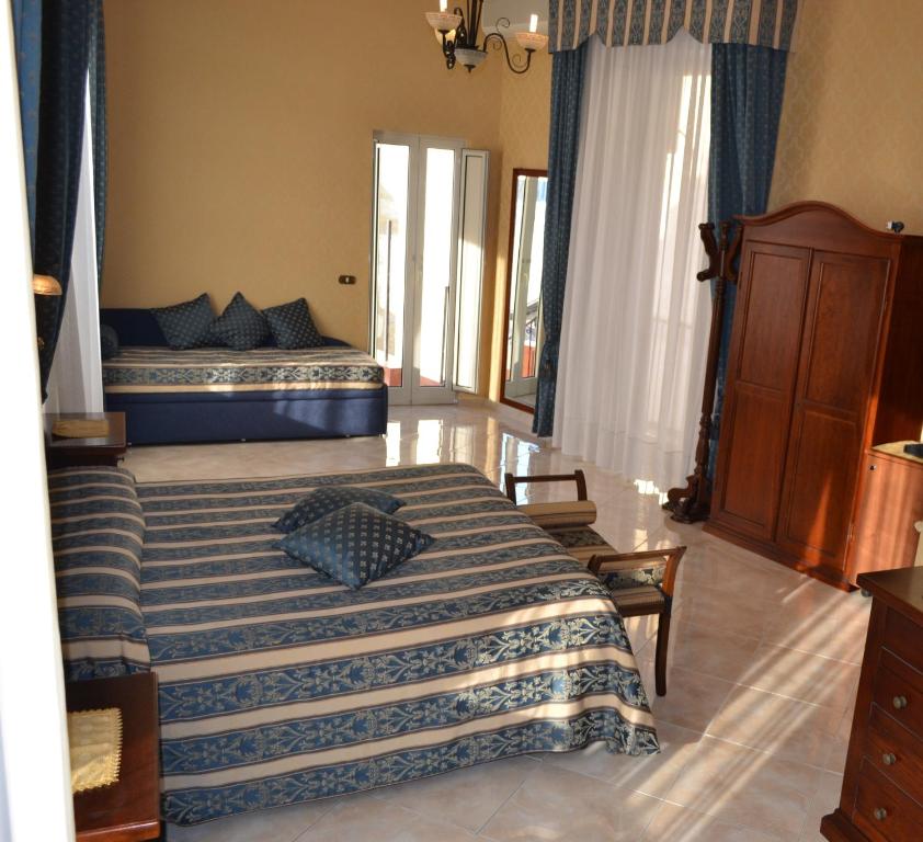 a bedroom with two beds with blue and white sheets at Bed & Breakfast Toledo in Naples