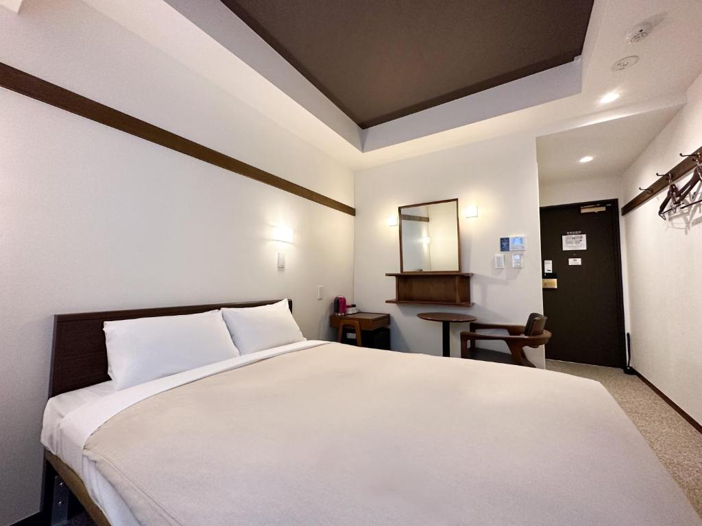 Un dormitorio con una gran cama blanca y una mesa en Hotel Emit Shibuya - Vacation STAY 40892v en Tokio