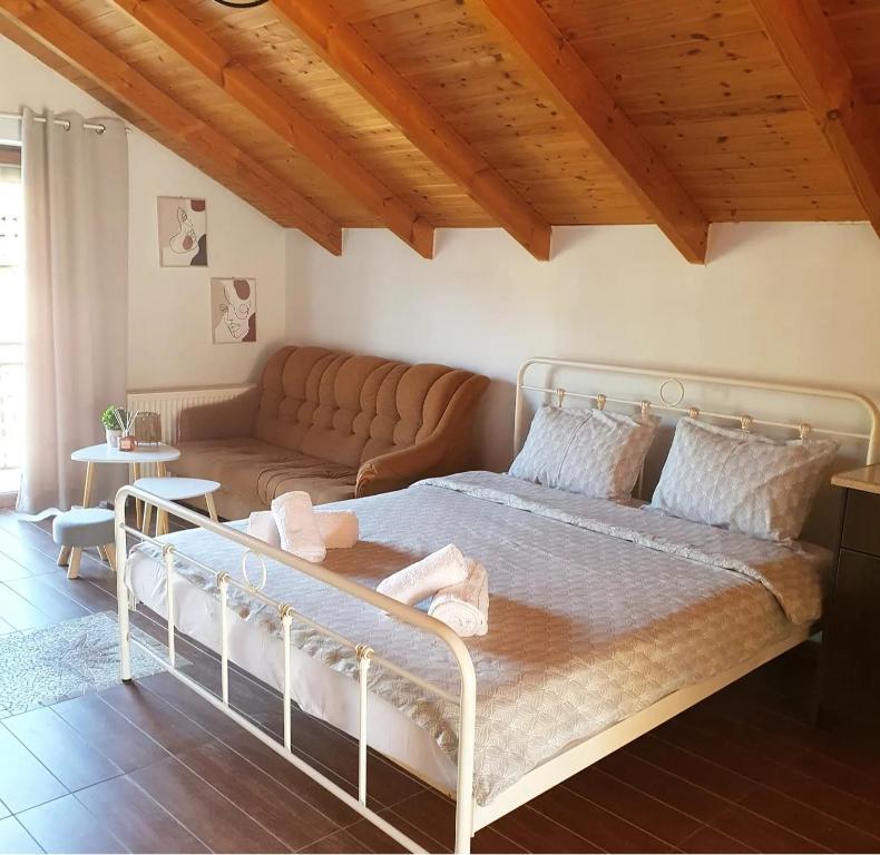 - une chambre avec un grand lit et un canapé dans l'établissement LittleLoft Ioannina, à Ioannina