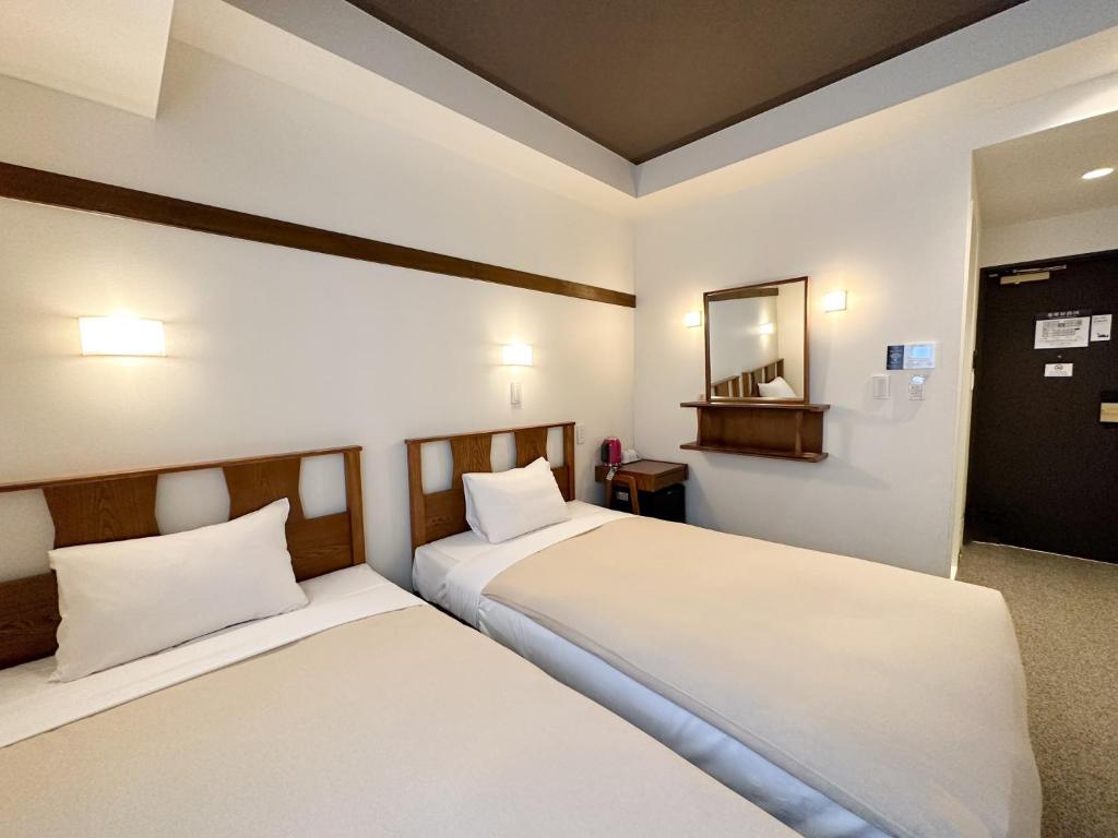 a bedroom with two beds and a mirror at Hotel Emit Shibuya - Vacation STAY 40894v in Tokyo