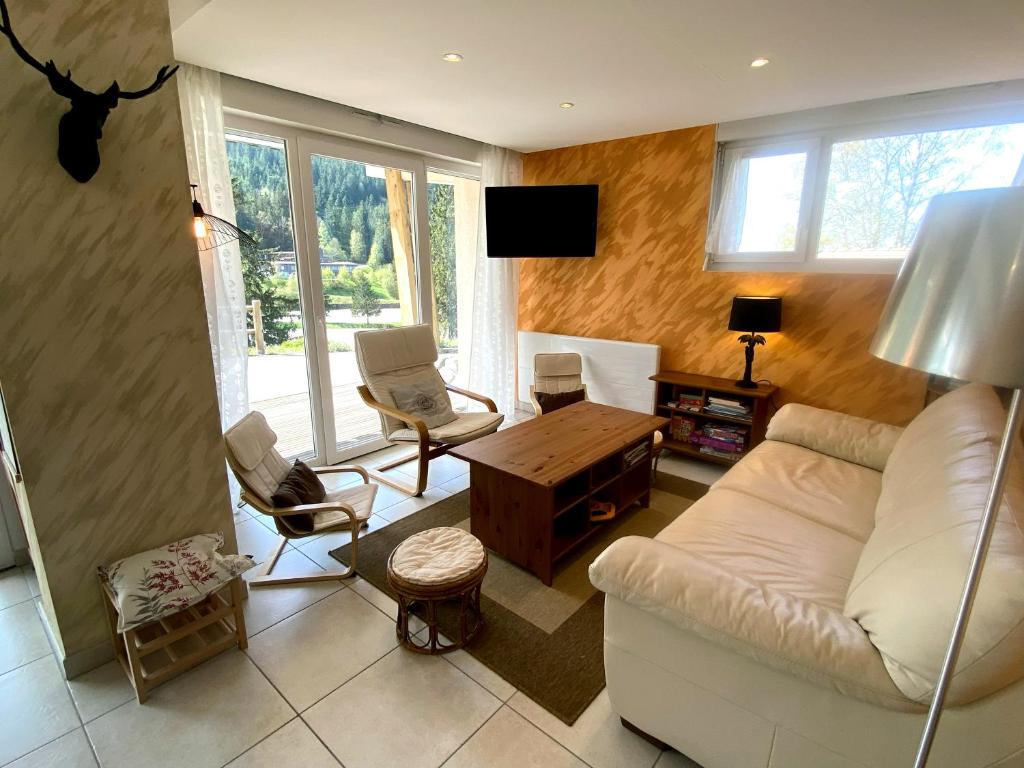 a living room with a white couch and chairs at Aux pieds des pistes 4/6 personnes in Gérardmer