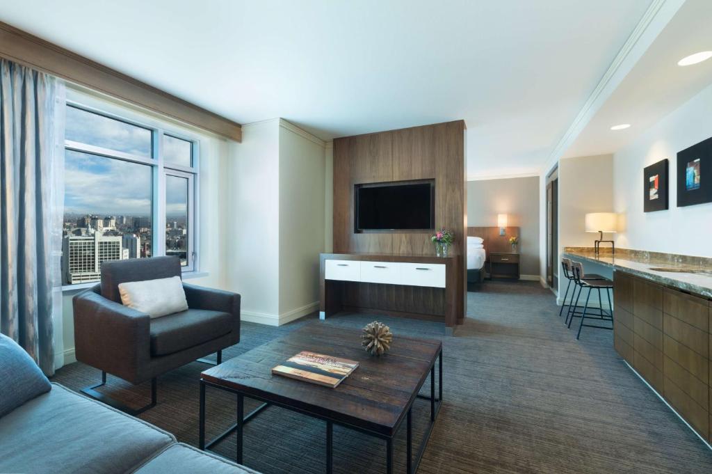 デンバーにあるハイアットリー ジェンシー デンバー アット コロラド コンベンション センターのソファとリビングルームが備わるホテルルームです。