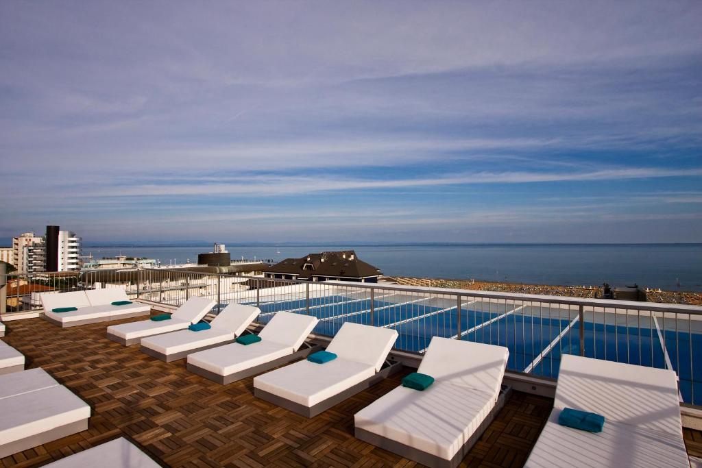 a row of chaise lounge chairs on the roof of a cruise ship at Hotel Florida in Lignano Sabbiadoro