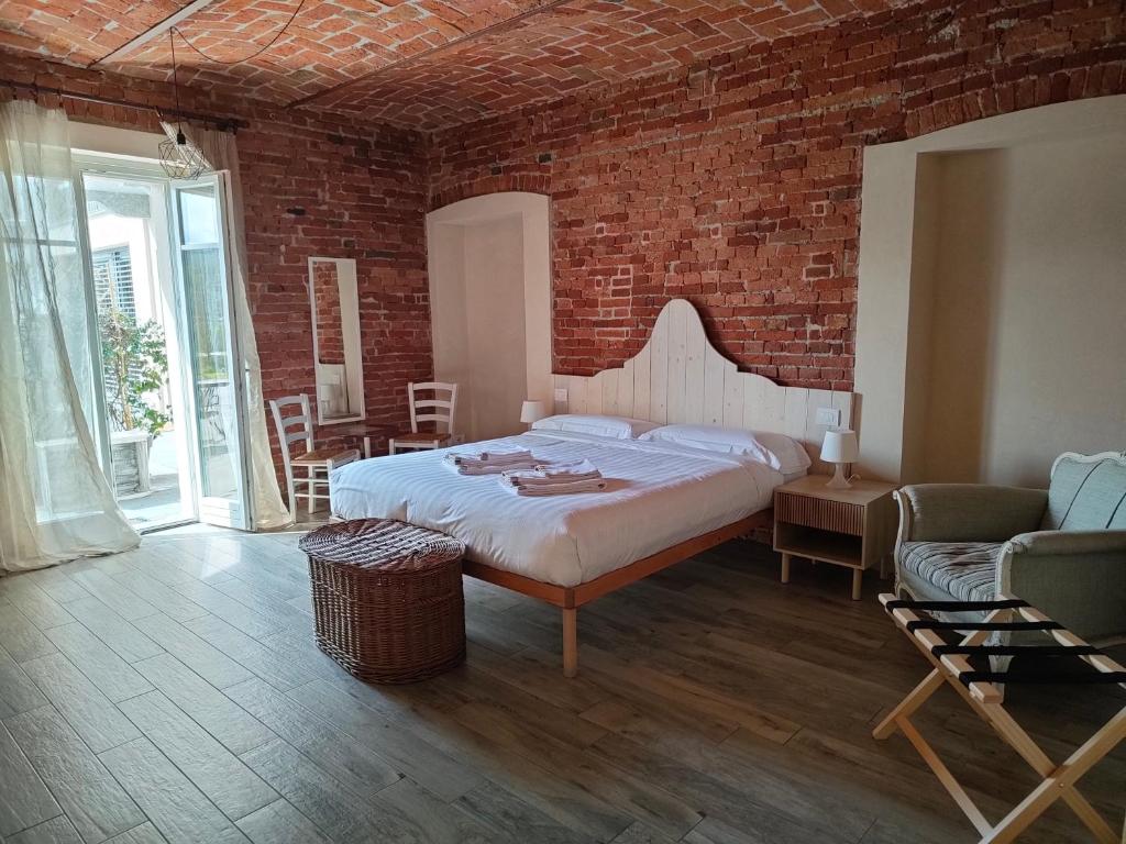 sypialnia z łóżkiem i ceglaną ścianą w obiekcie Cascina BELLONUOVO w Albie