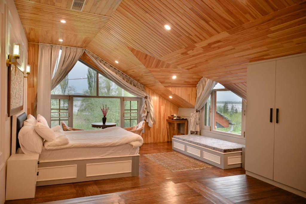 a bedroom with a large bed and a large window at Tree of Life Lakeside Cottage, Srinagar in Srinagar